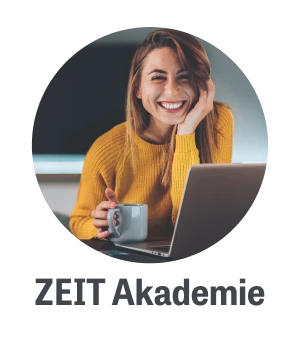 Junge Frau in einem gelben Pullover sitzt lächelnd vor einem Laptop und hält eine Tasse in der Hand, ideal für Themen wie Homeoffice oder digitales Arbeiten.